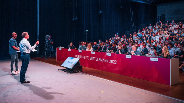 Bertelsmann lud Top-Student:innen aus ganz Europa nach Berlin ein. Personalvorstand Immanuel Hermreck und Moderator Amiaz Habtu begrüßten die Teilnehmenden zur 14. Ausgabe der Karriere-Veranstaltung ‚Talent Meets Bertelsmann‘. (© Bertelsmann)