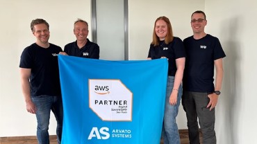 Mitarbeitende von Arvato Systems und einer Flagge zur Partnerschaft mit AWS