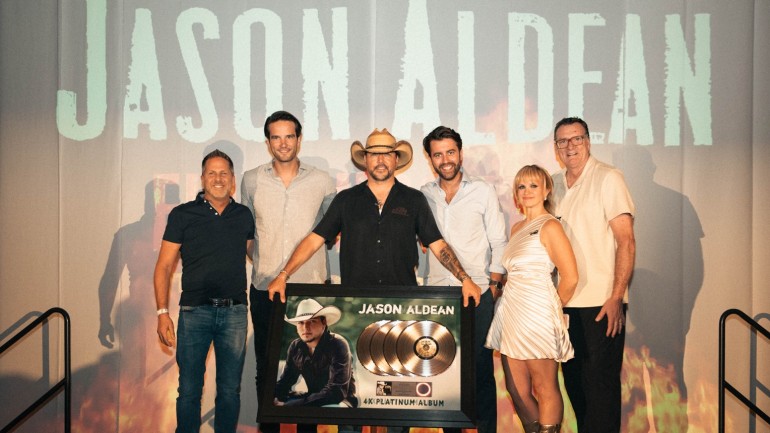 Jason Aldean mit dem BMG-Managemant auf einer Bühne