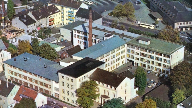 Seit dem Jahre 1868 hat das Haus Bertelsmann seinen Stammsitz an der Eickhoffstraße in Gütersloh. Geschäftsleitung, Verwaltung, Verlage und die Bertelsmann GmbH sind hier untergebracht. Hier in einer Vogelperspektive aus dem Jahr 1959.